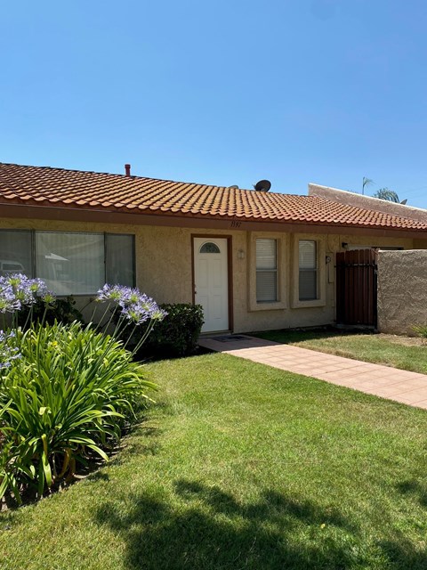 a small house with a yard and a walkway