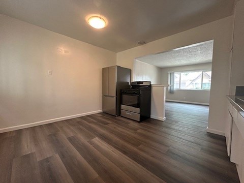 A room with a wood floor and a wall-mounted TV.