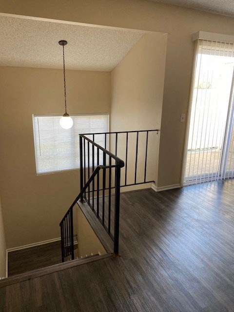 A staircase with a black railing and a light hanging from the ceiling.