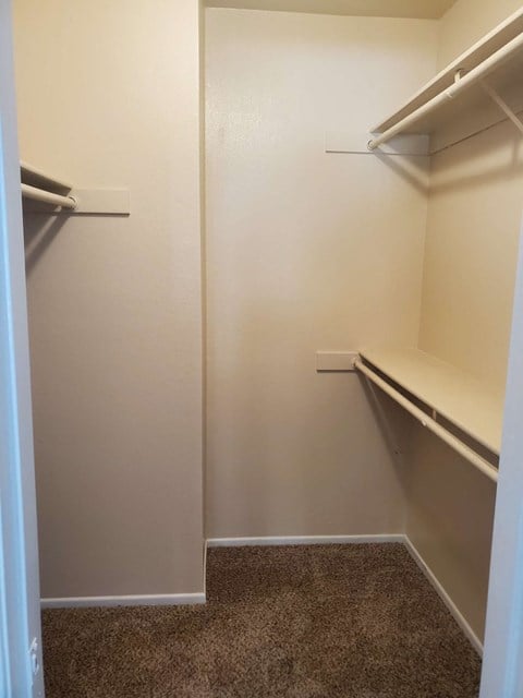 a walk in closet with empty shelves
