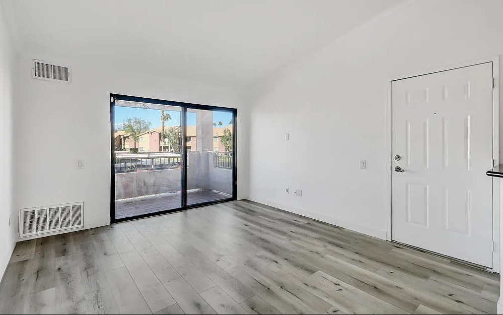 a bedroom with a door leading to a balcony