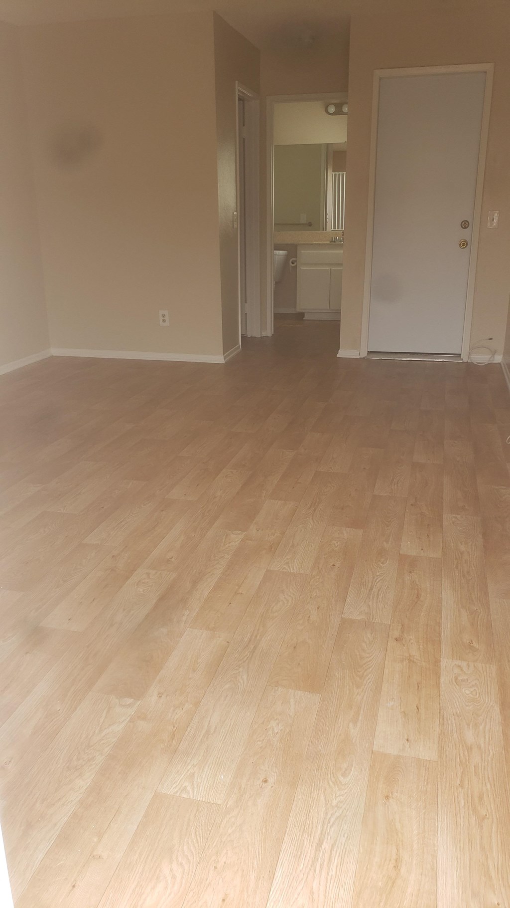 an empty living room with a wooden floor