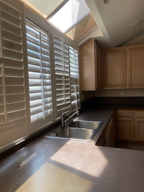 A kitchen with a sink and wooden cabinets.