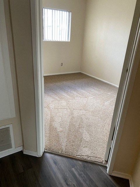 A room with a carpet and a window.