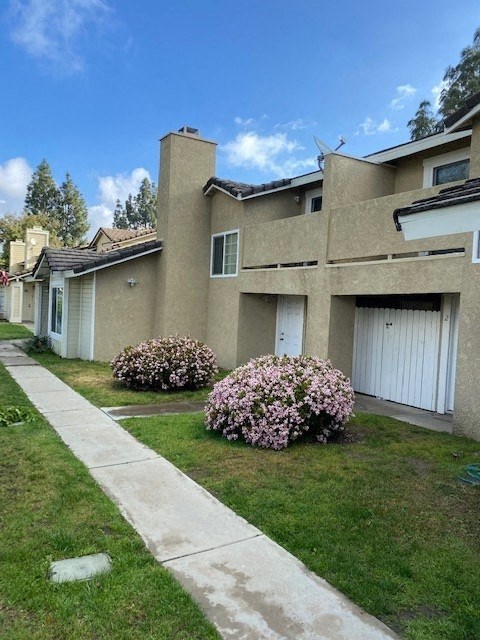 A row of houses with a sidewalk in front.