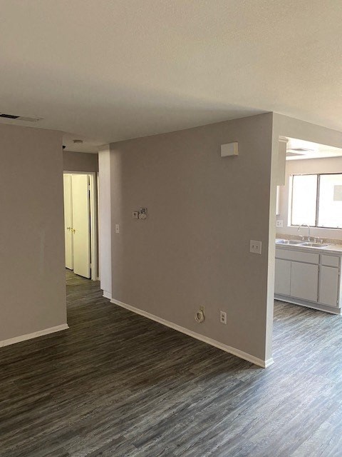 an empty living room and kitchen with wood flooring
