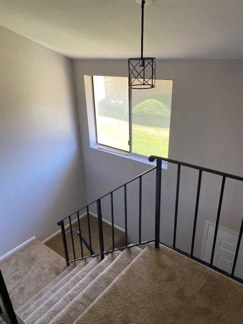 a staircase with a window and a chandelier