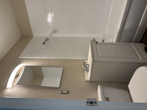 A bathroom with a toilet, sink, and shower.