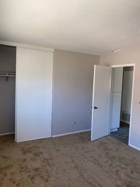 an empty room with an open door and a closet