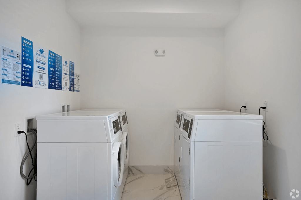 two washer and dryers in a laundry room with white walls