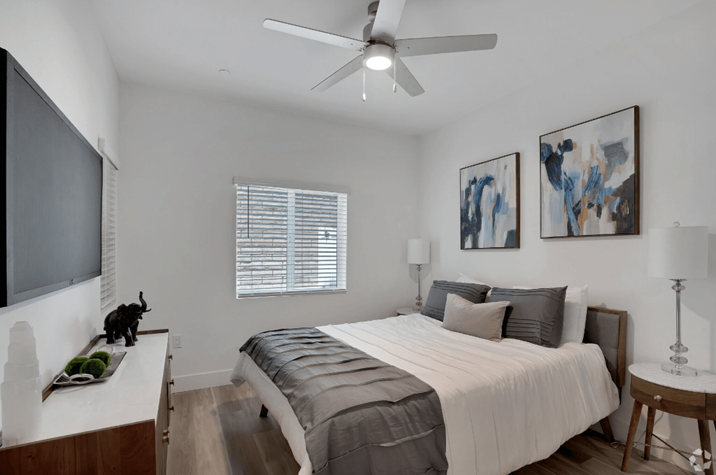 a bedroom with a large bed and a ceiling fan