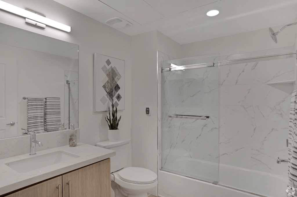 a bathroom with a shower and a sink and a toilet