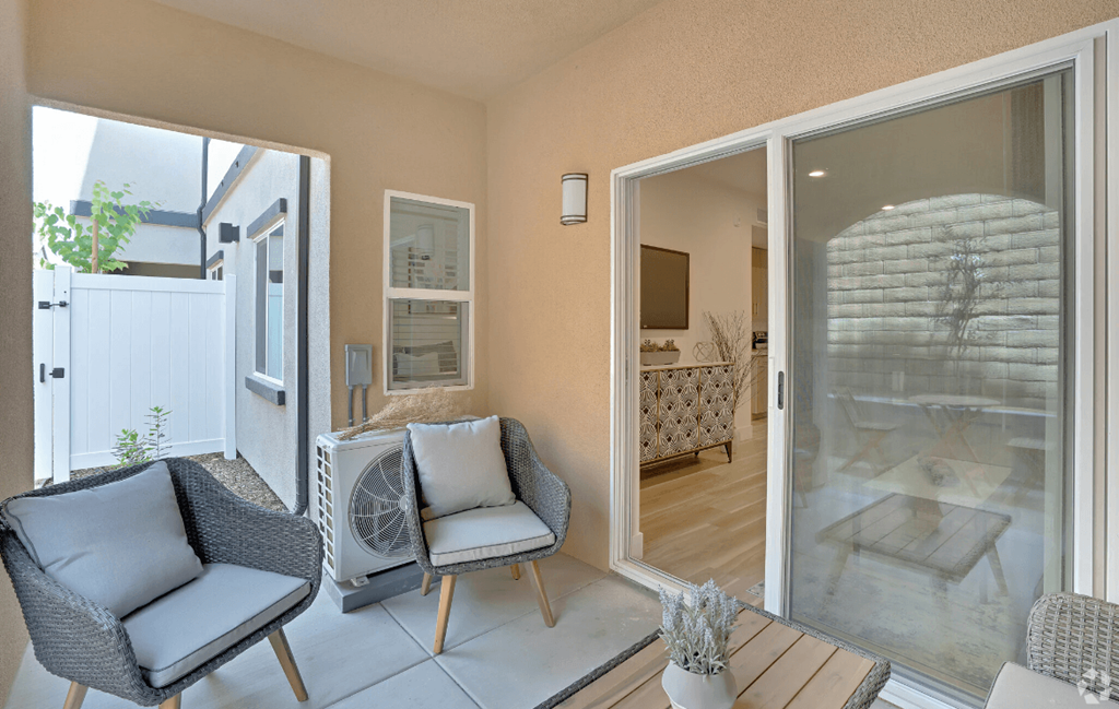 a living room with two chairs and a sliding glass door