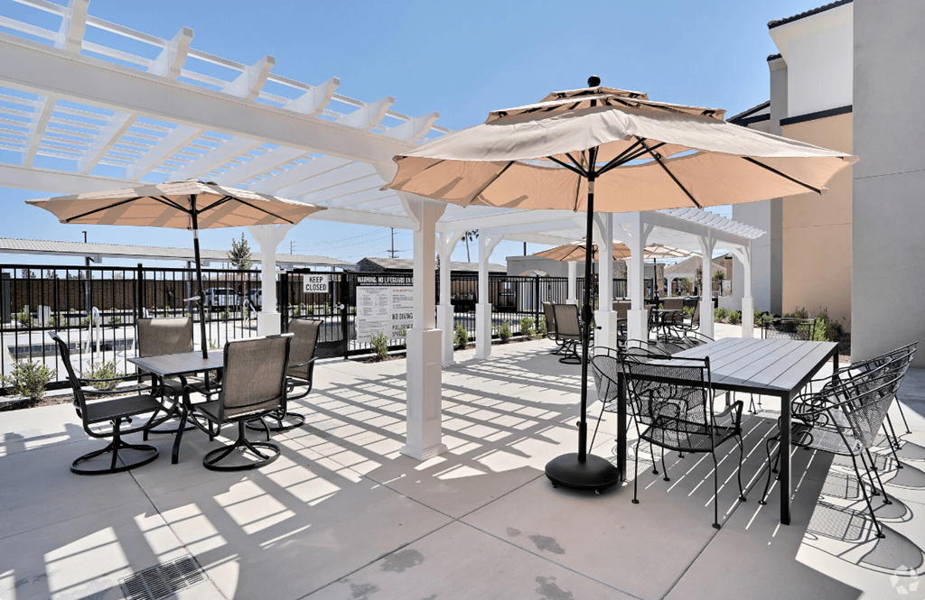 a patio area with umbrellas and tables and chairs