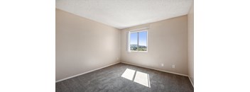 an empty room with carpet and a window