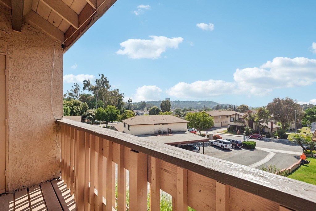 the view from the balcony of a house overlooking a parking lot