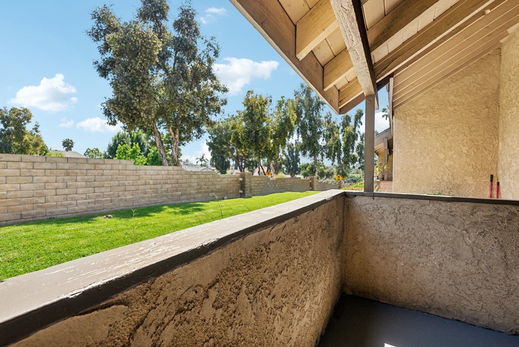 a large terrace with grass and trees in the background