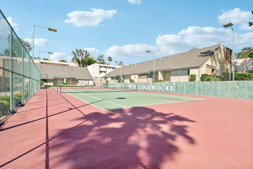 a tennis court with a house in the background