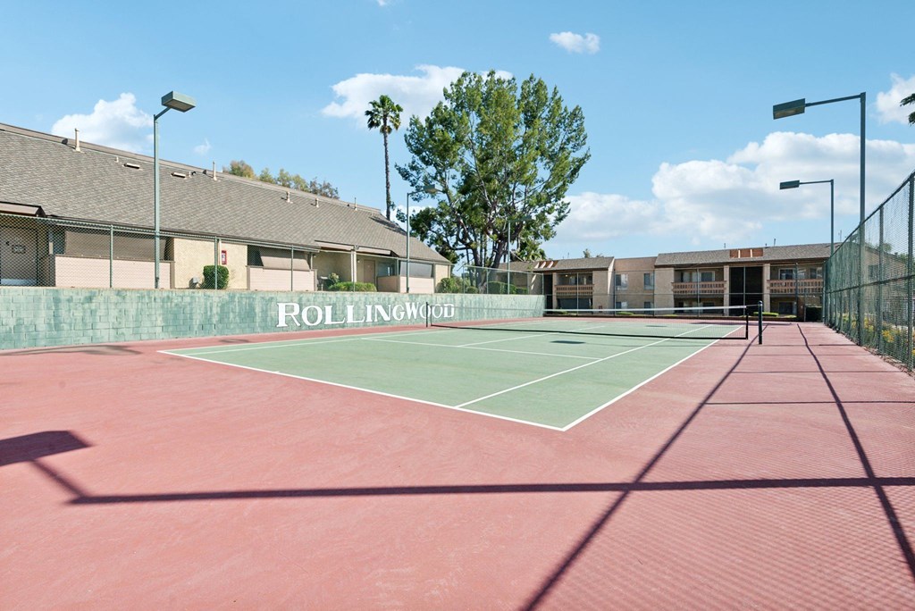 a tennis court with a building in the background