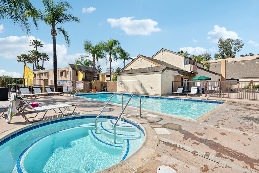 our apartments have a resort style pool with chairs and palm trees