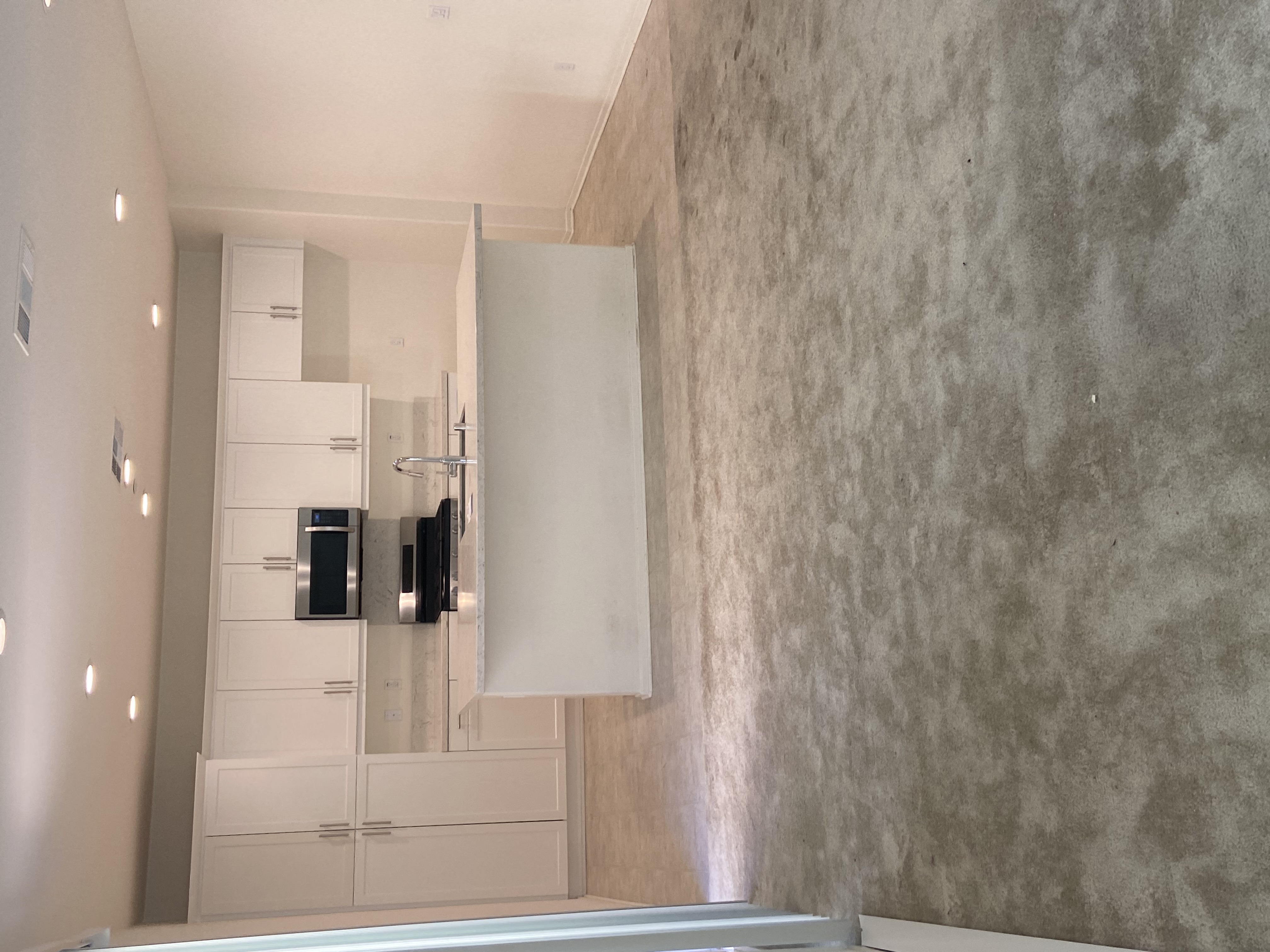 a view of a bathroom with a cement wall and a mirror