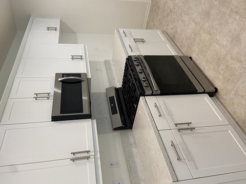 an overhead view of a kitchen with white cabinets and appliances