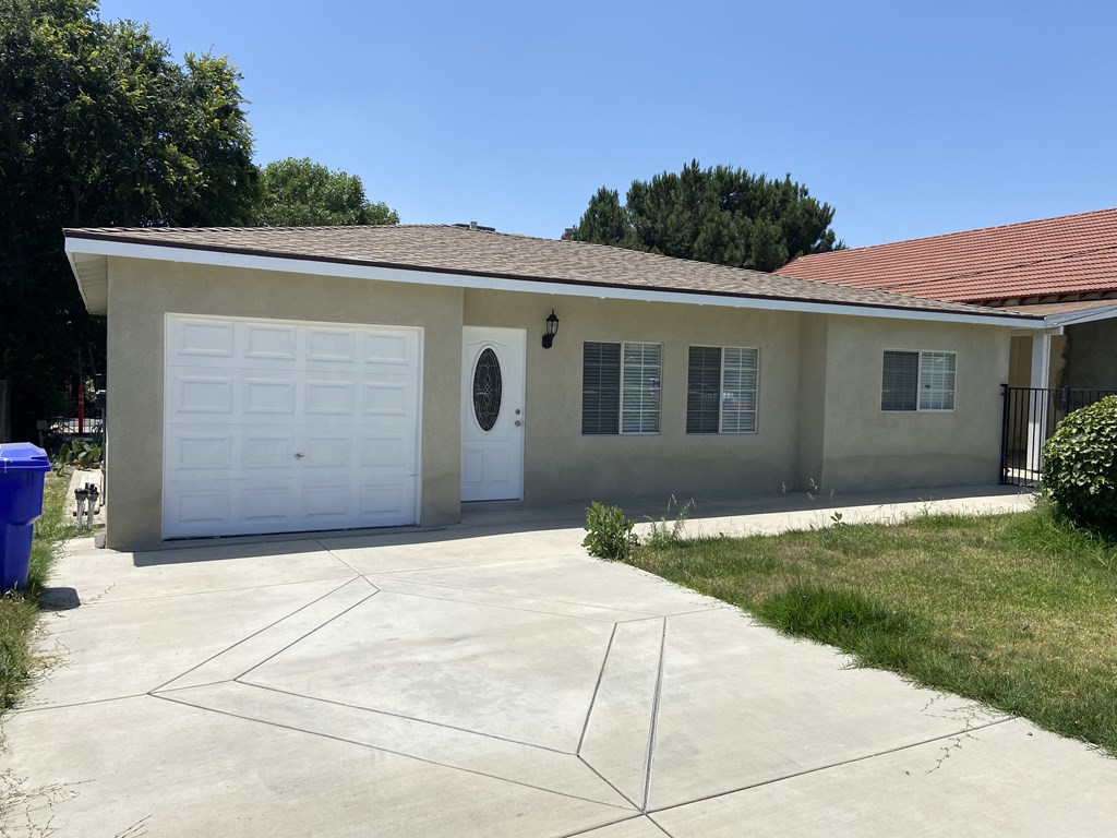 a white house with a white garage door and a driveway