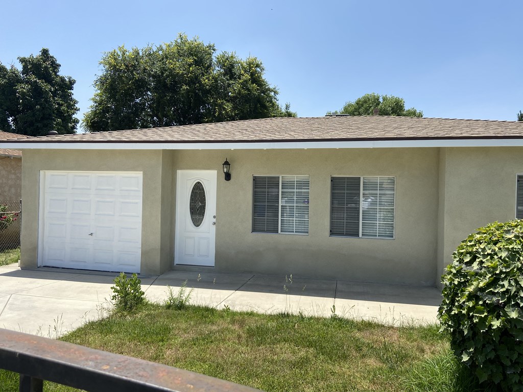 a white house with two white garage doors and a lawn