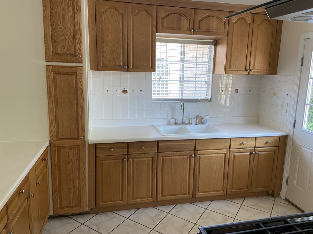 an empty kitchen with wooden cabinets and a sink