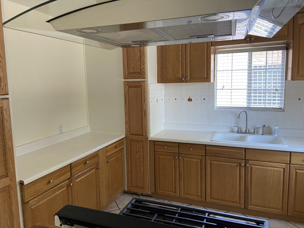 a kitchen with wooden cabinets and a stove and a sink