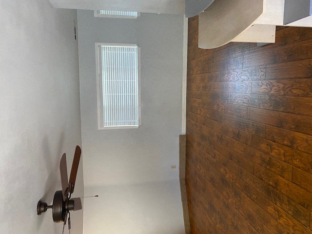 an empty room with a wooden door and a white wall and a window