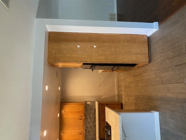 a room with a refrigerator and a lowered ceiling