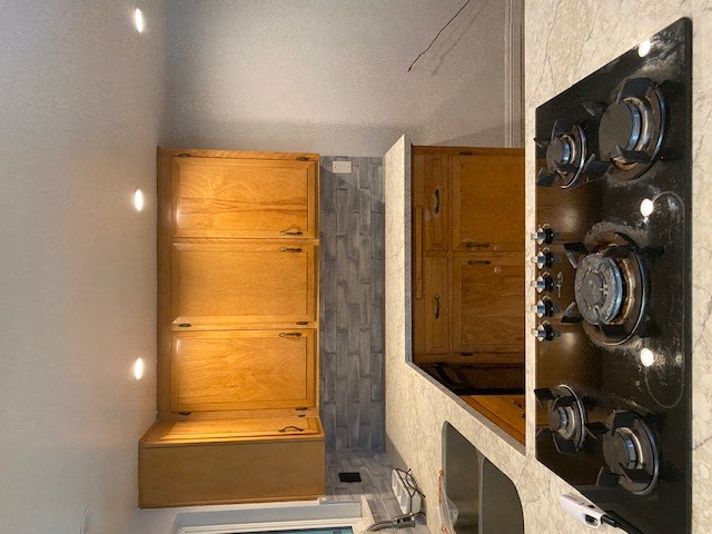 a small kitchen with wooden cabinets and stainless steel pots and pans