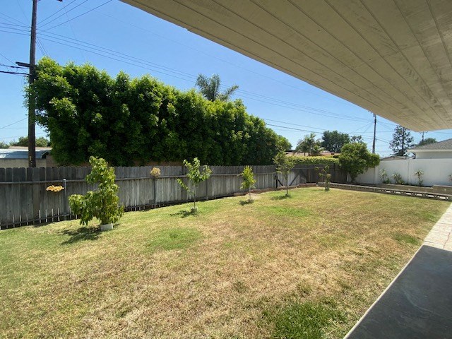 a backyard with a fenced in yard and some trees