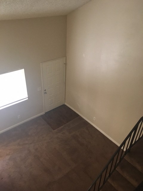 A room with a brown carpet and a white door.