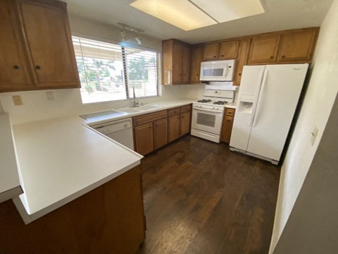 A kitchen with wooden cabinets and white appliances.