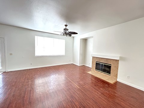 A room with a fireplace and wood flooring.