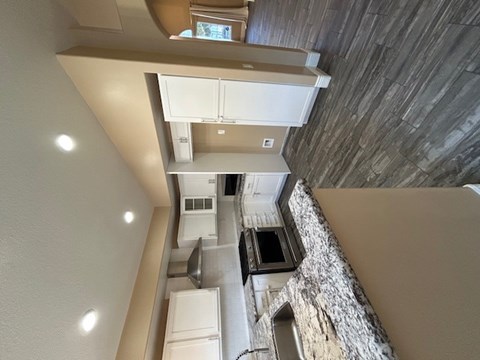 A view from the top of a staircase looking down into a kitchen.
