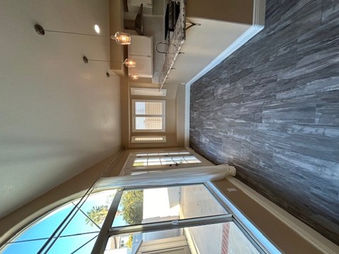 A long hallway with a stone wall on the right and a window on the left.