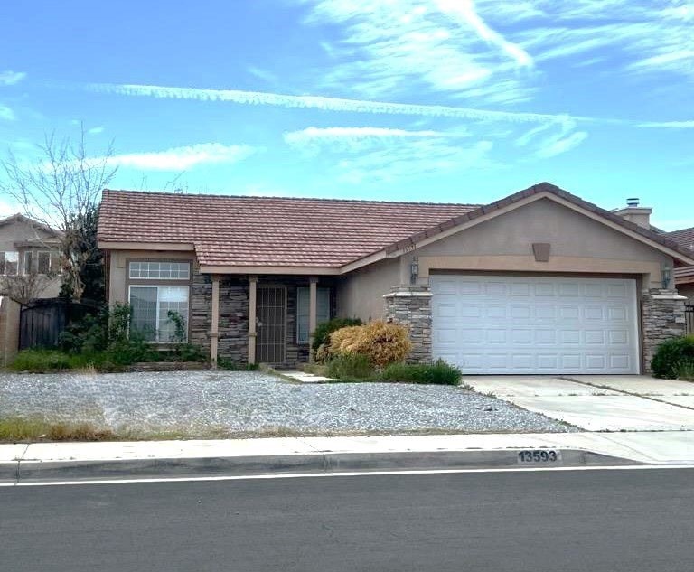 A house with a garage and a driveway in front.
