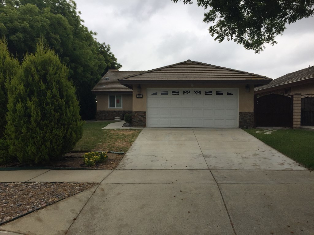 a house with a concrete driveway and a white garage door