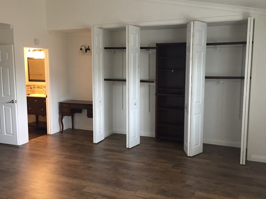 an empty room with two closets and a bathroom in the background
