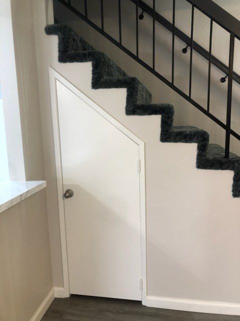 A staircase with a white door at the bottom.