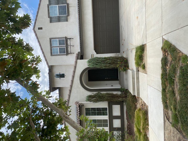 A house with a grey wall and a black door.