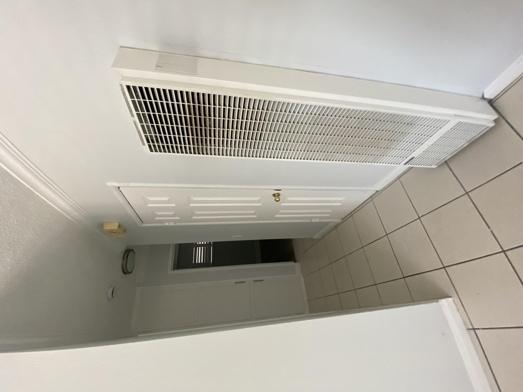 A white ceiling with a vent and a small window.