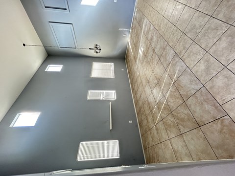 A bathroom with a tiled floor and walls.