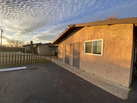 A house with a brown stucco exterior and a wooden fence.