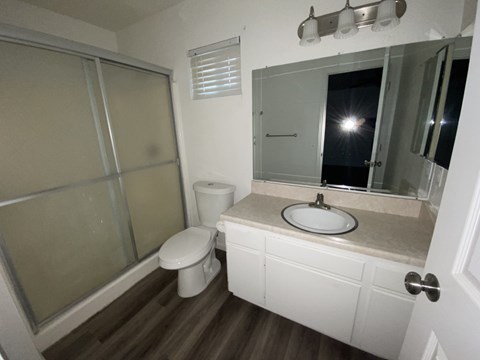 A bathroom with a toilet, sink, and mirror.