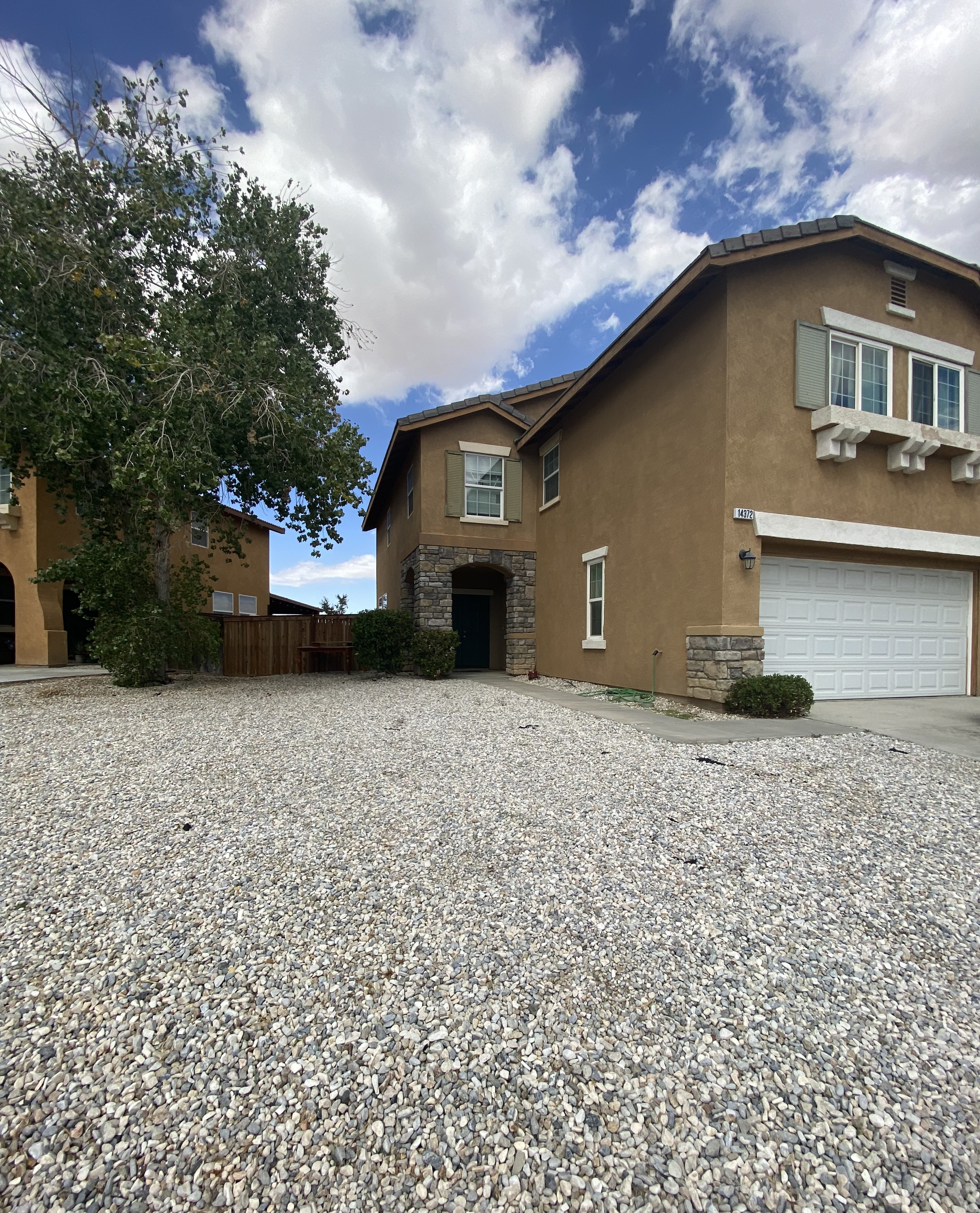 A house with a gravel driveway in front.