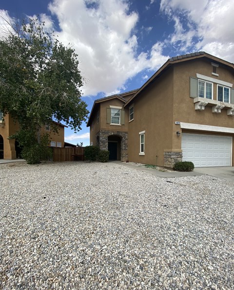 A house with a gravel driveway in front.